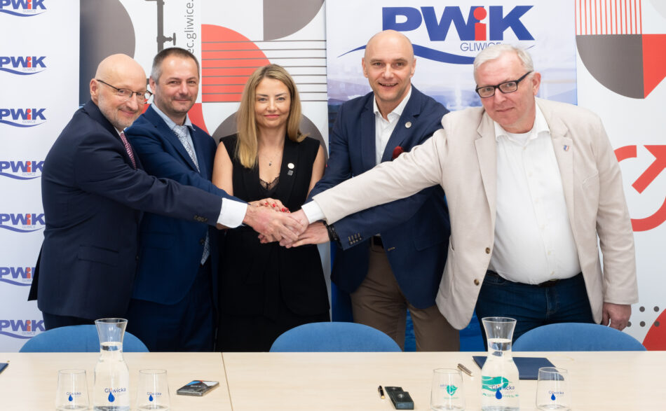 Technologia będzie działała w oparciu o odzysk ciepła ze ścieków oczyszczonych opuszczających Centralną Oczyszczalnię Ścieków. Ciepło zawarte w ściekach zostanie odebrane przez wymienniki ciepła, a następnie przekazane do wielkoskalowej pompy ciepła. Urządzenie podniesie temperaturę energii do parametrów wymaganych przez miejską sieć ciepłowniczą i przekaże ją do systemu PEC Gliwice. Kluczową rolą integratora będzie zapewnienie stabilnej współpracy pomiędzy infrastrukturą oczyszczalni, układem pomp ciepła oraz miejskim systemem ciepłowniczym. Obejmuje to także przygotowanie zaawansowanego systemu automatyki odpowiedzialnego za optymalizację pracy instalacji w zależności od temperatur zewnętrznych, zapotrzebowania sieci oraz parametrów ścieków. – Konsekwentnie rozwijamy działania związane z dywersyfikacją źródeł ciepła i zwiększaniem niezależności energetycznej miasta. Poszukujemy lokalnych potencjałów energetycznych, które pozwolą nam produkować ciepło w sposób bardziej efektywny, stabilny i przyjazny środowisku. Wykorzystanie ciepła zawartego w ściekach to przykład nowoczesnego podejścia do ciepłownictwa, które jednocześnie zwiększa bezpieczeństwo dostaw dla mieszkańców i ogranicza konieczność korzystania z paliw kopalnych oraz surowców dostarczanych z zewnątrz – tłumaczy Krzysztof Szaliński, prezes PEC Gliwice. Projekt ma charakter strategiczny dla transformacji energetycznej Gliwic. Dzięki wykorzystaniu ciepła odpadowego miasto zwiększy udział odnawialnych i niskoemisyjnych źródeł energii w ciepłownictwie systemowym, jednocześnie poprawiając bezpieczeństwo energetyczne oraz efektywność produkcji ciepła. Inwestycja wpisuje się również w europejskie kierunki dekarbonizacji sektora ciepłowniczego i rozwoju gospodarki obiegu zamkniętego. Szacowana wartość całego przedsięwzięcia wynosi około 100–120 mln zł. Projekt jest współfinansowany przez Narodowy Fundusz Ochrony Środowiska i Gospodarki Wodnej. Inwestycja ma być gotowa z końcem 2027 roku. UWAGA! NA ZDJĘCIU UCZESTNICZY UROCZYSTOŚCI PODPISANIA UMÓW. OD LEWEJ: Paweł Bachorz (wiceprezes Grupy KDM), Jakub Kowalczyk (wiceprezes Grupy KDM), Patrycja Jurkiewicz-Cygan (wiceprezes PEC-Gliwice ds. finansowych), Krzysztof Szaliński (prezes PEC-Gliwice), Tomasz Brągiel (prezes PWiK Gliwice – spółki na terenie, której inwestycja powstanie).